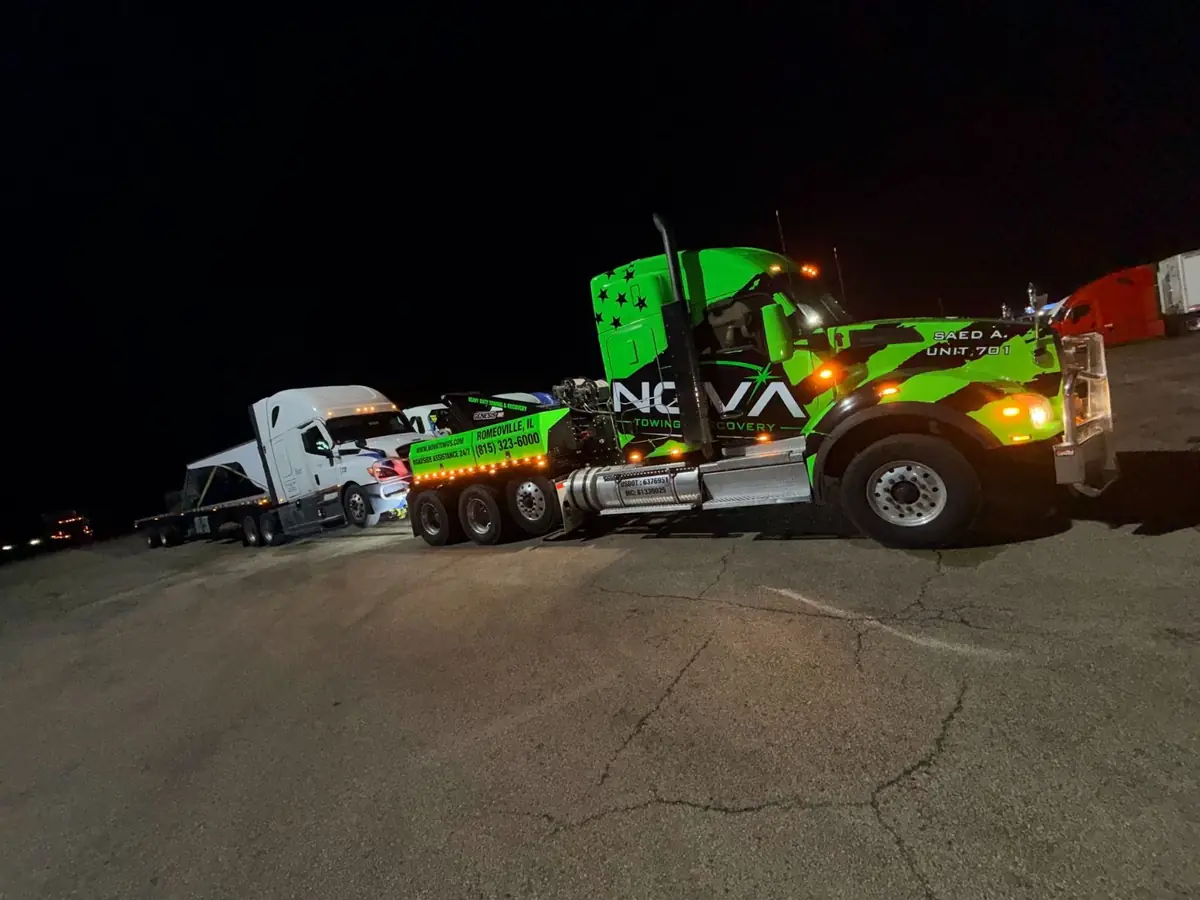 NOVA wrecker towing a semi truck at night